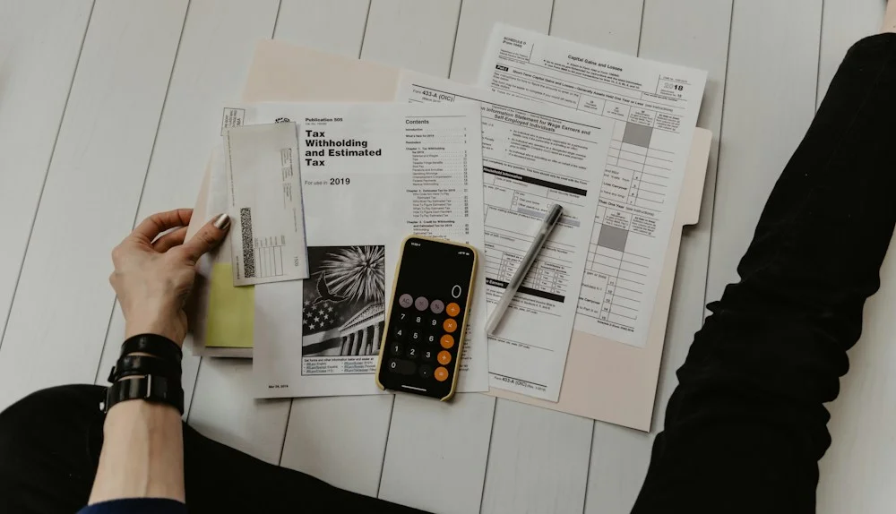 Calculator and paperwork for reviewing financial commitments